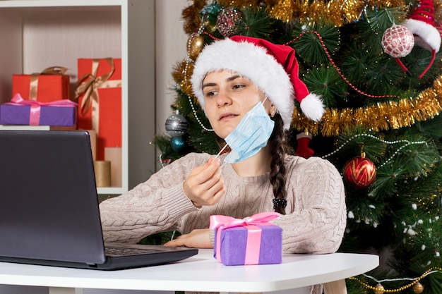 A woman removes a medical mask from her face, making online purchases