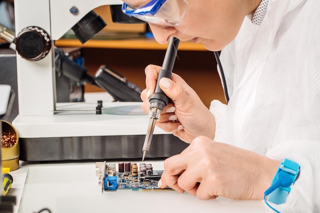 Woman repairing computer hardware in service center Repairing and fixing service in lab Electronics repair service concept