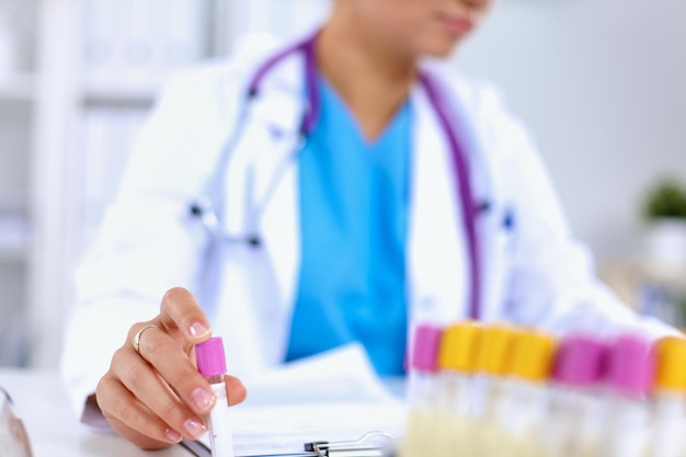 Woman researcher is surrounded by medical vials and flasks, isolated on white background