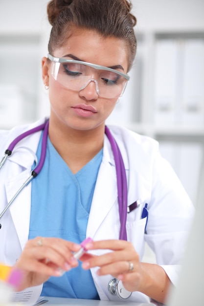 Woman researcher is surrounded by medical vials and flasks isolated on white background