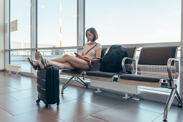 Woman resting in arrival hall waiting for a transfer at airport