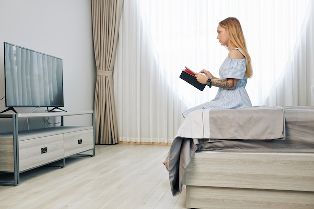 Woman resting in bedroom in front of tv