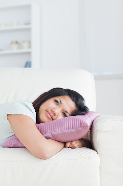 Photo woman resting her head on a pillow while lying on a couch