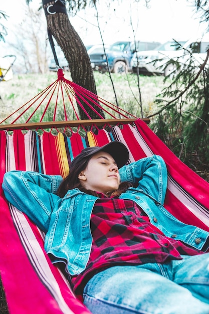 Woman resting laying down in hammock between trees