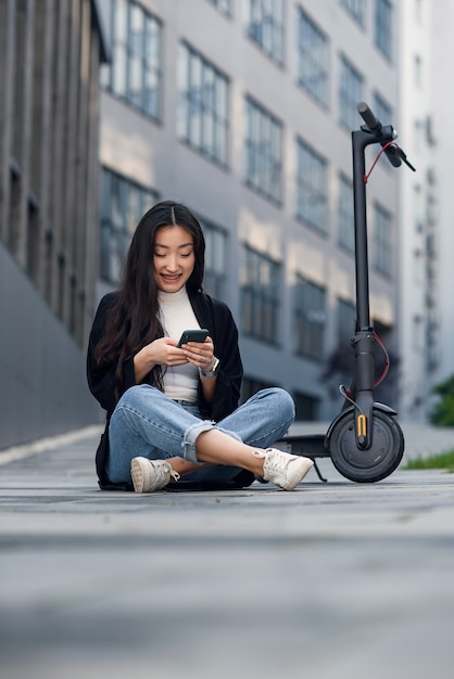 電動スクーターの近くで休んでいる女性