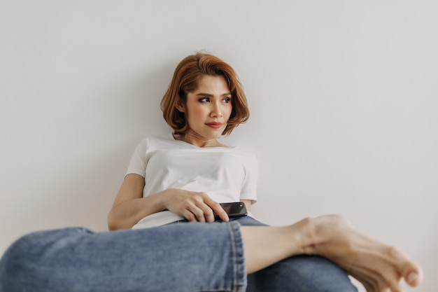 Woman resting and relax in the room with her smartphone in hand