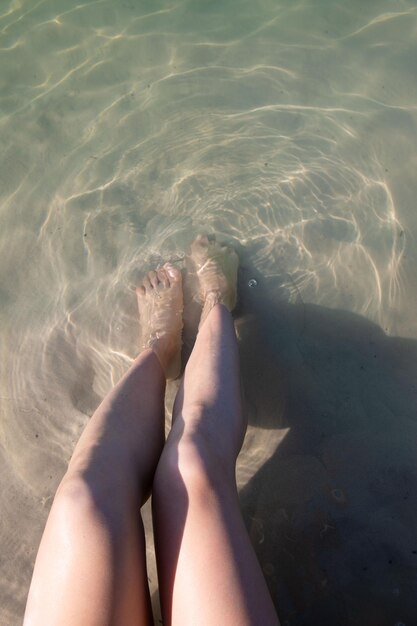 Foto donna che riposa sulla spiaggia sabbiosa