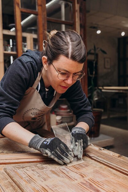 Woman restoring in artisanal way piece of wood