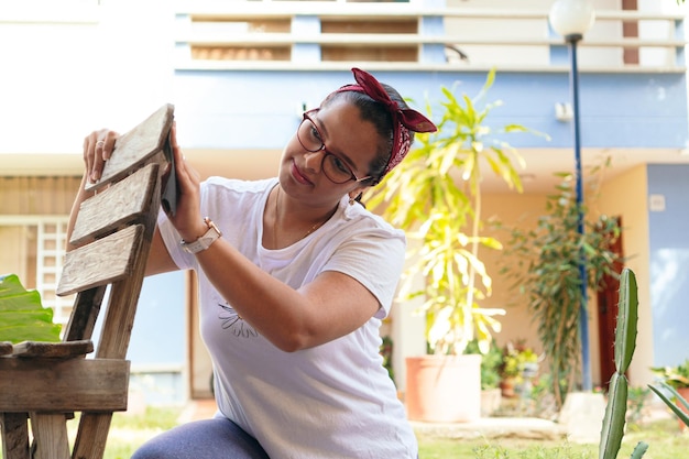 Woman restoring an old chair at home