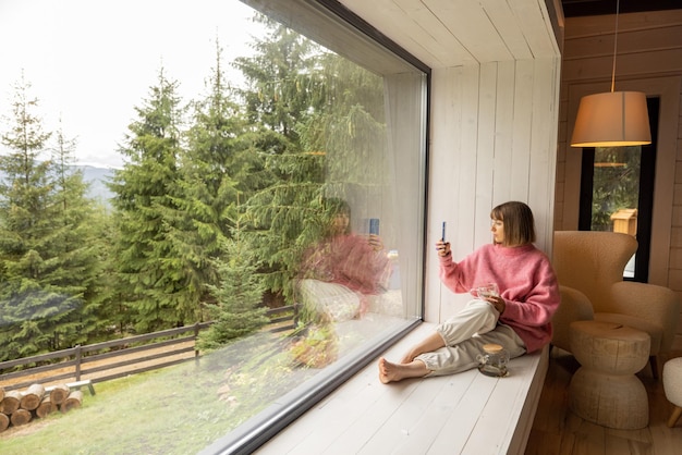 Foto la donna riposa in casa con vista panoramica sulle montagne