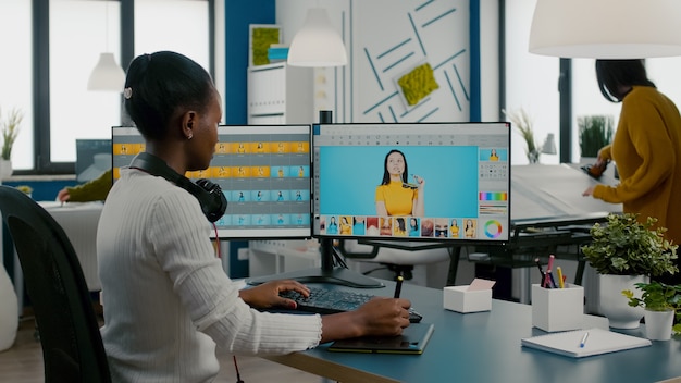 woman retoucher sitting in modern creative photo studio working on computer after photoshoot