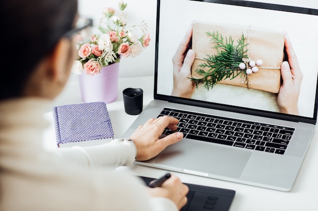 woman retouching on computer laptop using digital tablet and stylus pen