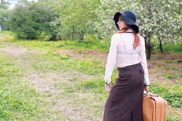 Woman in retro dress outdoor suitcase park