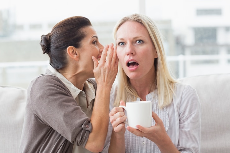 Photo woman revealing secret to her surprised friend