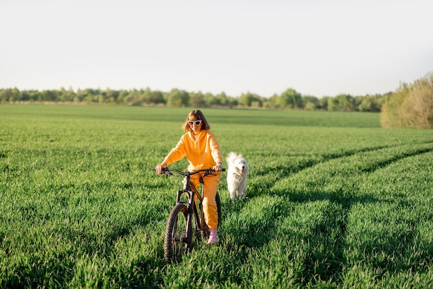 女性はフィールドで自転車に乗る