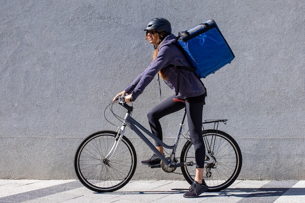 写真 自転車に乗って市内で注文を配達する女性