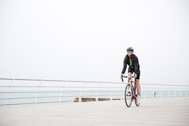 Woman riding on a bicycle outdoors on the beach