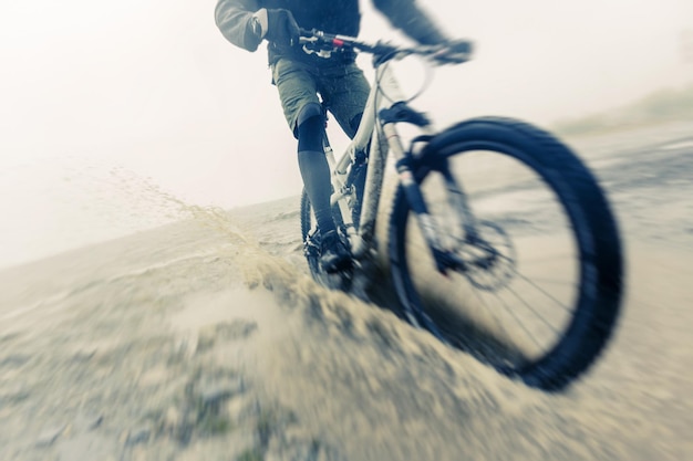 Photo woman riding bicycle on wet road against sky