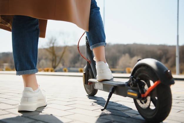 Foto la donna in sella a uno scooter elettrico all'aperto