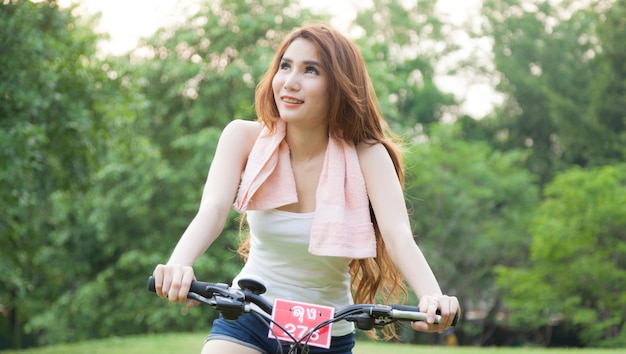 Woman riding an exercise bike in the park.