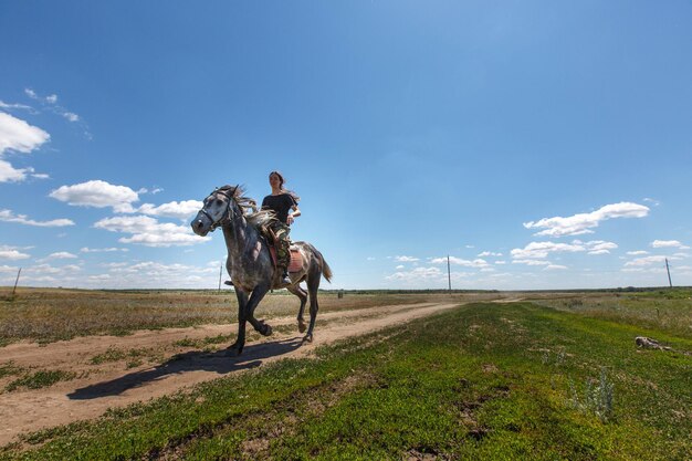 Foto donna a cavallo sul campo contro il cielo