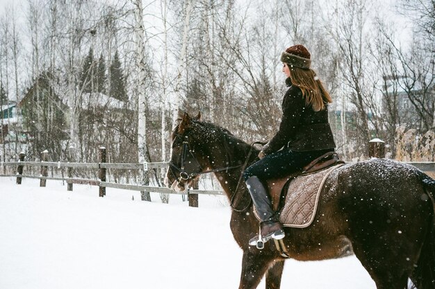 Фото Женщина едет на лошади по покрытому снегом пейзажу