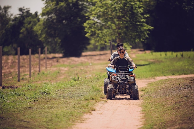 woman riding quad atv vehicle running on dirt field