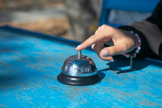 Woman ringing service bell on the table