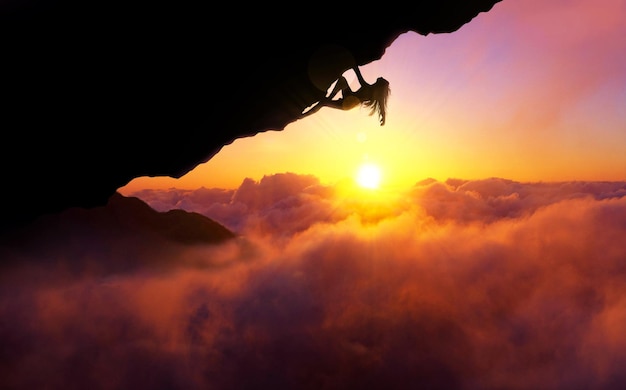 Foto donna che si arrampica su una parete nuvolosa contro il cielo durante il tramonto