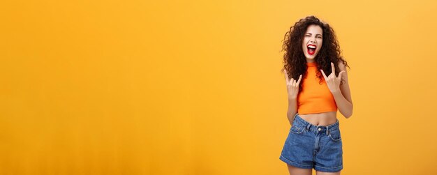 Woman rocking and enjoying great concert dancing yelling out loud from amazement and thrill showing