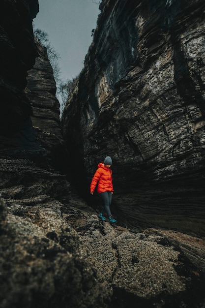 Donna su una spiaggia rocciosa a spar cave sull'isola di skye in scozia