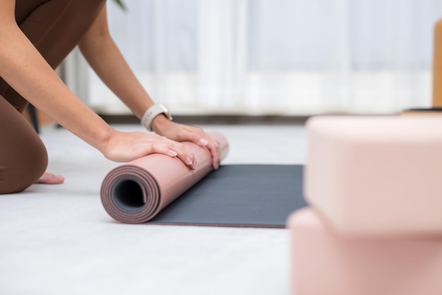 Woman roll her yoga mat after class