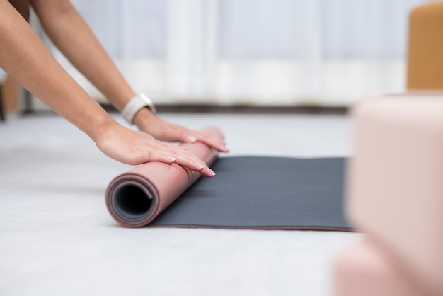 Woman roll her yoga mat after class