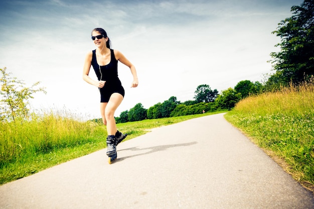 Woman roller skating on footpath against sky