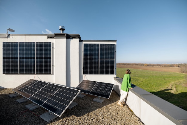 Woman on the roof of her house with a solar station