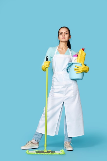 Woman in rubber gloves with cleaning supplies and mop