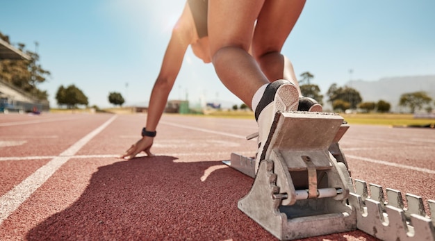 女性ランナーとトラックでのスポーツイベントやレースのためのランニングトレーニングとエクササイズの開始若い女性スポーツ選手は、持久力とフィットネスのためのトレーニングチャレンジスピードとマラソンの準備ができています