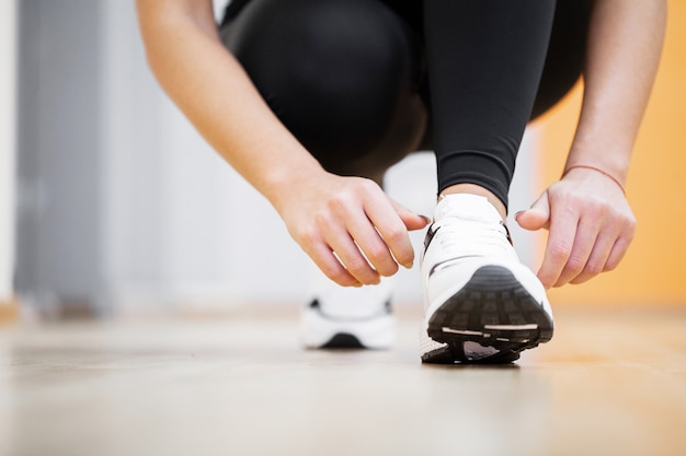 Woman Runner Tightening Shoe Lace, Runner Woman Feet Running On Road Closeup On Shoe