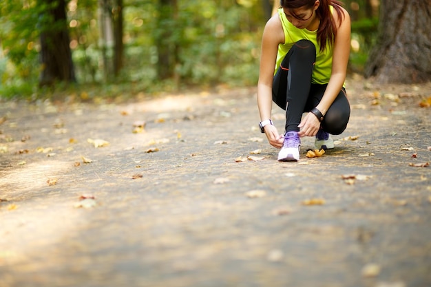 Corridore donna che allaccia i lacci delle scarpe