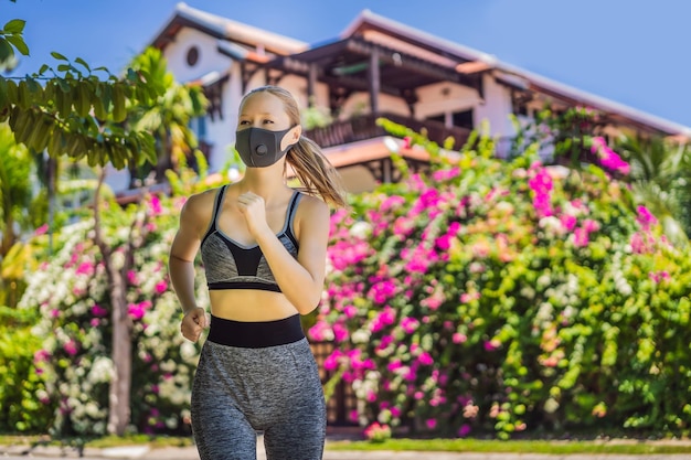 公園内を走る医療用マスクを着た女性ランナー、コロナウイルスのパンデミック、コビッドスポーツ、アクティブライフ