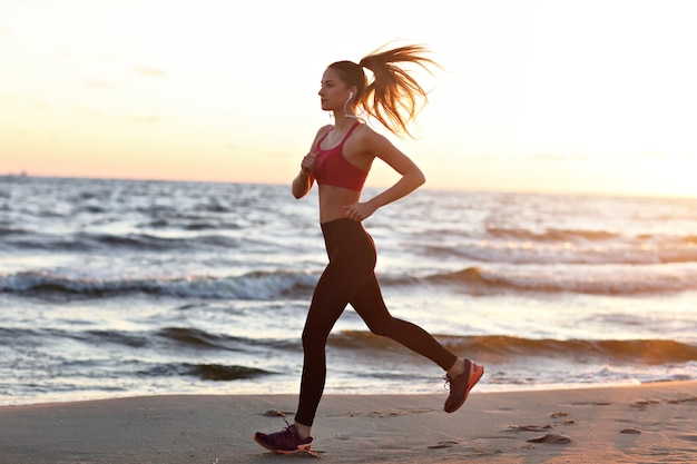 woman running alone at beautiful dusk on the beach