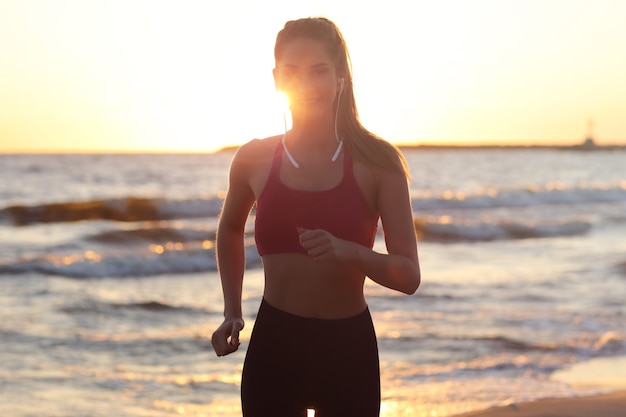 woman running alone at beautiful dusk on the beach