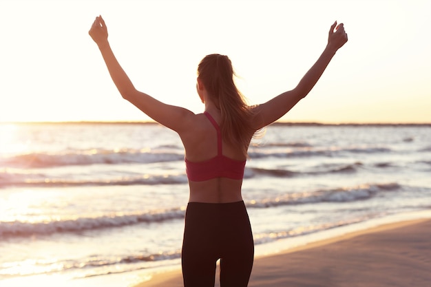 woman running alone at beautiful dusk on the beach