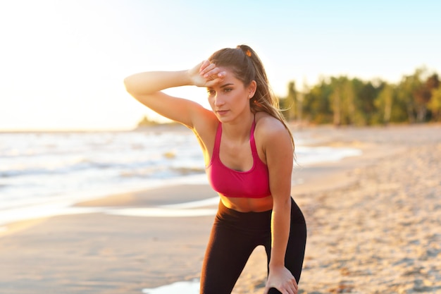 woman running alone at beautiful dusk on the beach