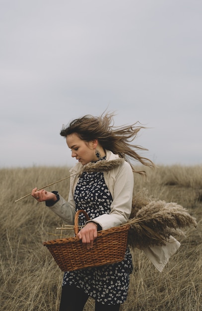 A woman running on the field with dry grass in the fall. Moments of happiness and freedom