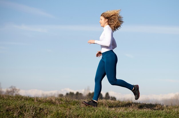 Foto donna che corre nei campi