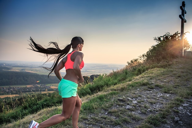 Woman running on mountain during sunset