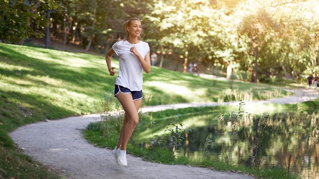 Woman running road summer park