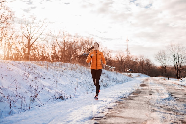 Woman running at snowy mountain.