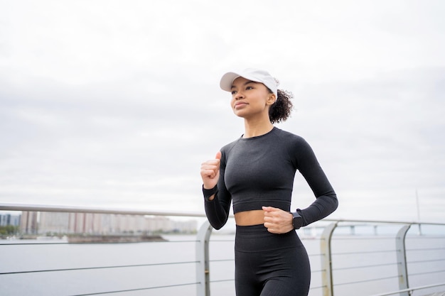 Женщина бегает занимается фитнесом использует трекер на руке умные часы для занятий спортом тренируется в спортивной одежде